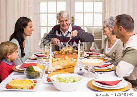 Grandfather carving chicken during christmas dinner 12840240