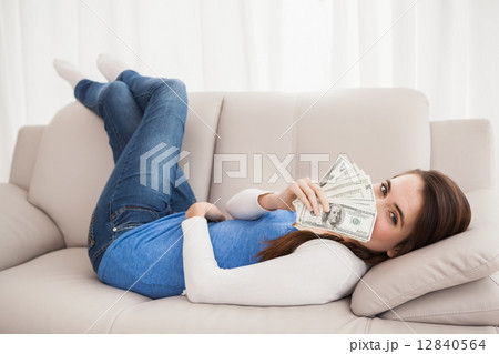 Pretty brunette showing cash on couch Pretty brunette showing cash on couch 12840564