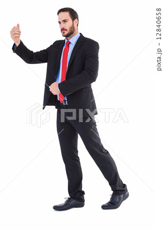 Serious businessman standing with arms raised 12840658