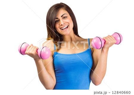 Smiling fit brunette holding dumbbells 12840660