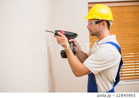 Construction worker drilling hole in wall Construction worker drilling hole in wall 12840963