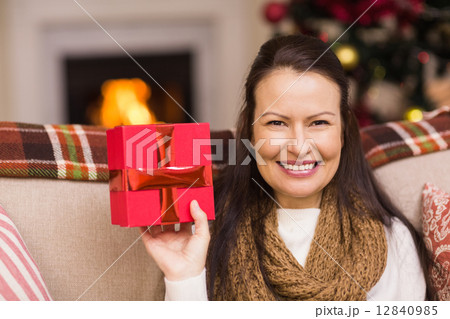 Pretty brunette woman showing christmas gift 12840985