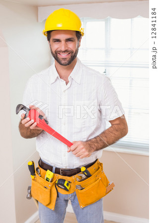 Handyman smiling at camera in tool belt Handyman smiling at camera in tool belt 12841184