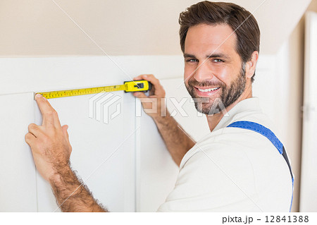 Handyman measuring a wardrobe 12841388