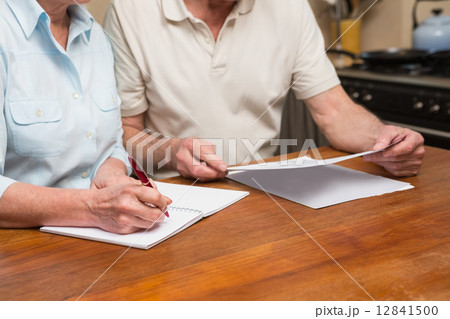 Senior couple reading and writing 12841500