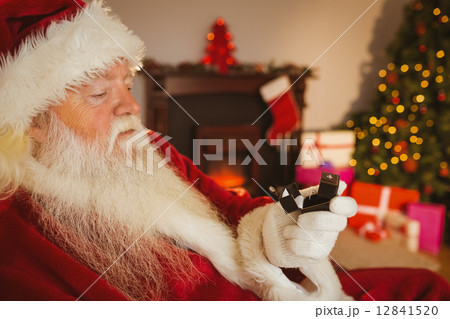 Santa claus holding engagement ring with his box Santa claus holding engagement ring with his box 12841520