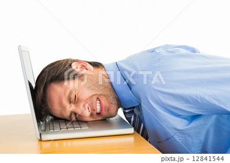 Businessman resting head on keyboard Businessman resting head on keyboard 12841544