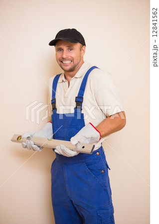 Confused construction worker holding spirit level Confused construction worker holding spirit level 12841562