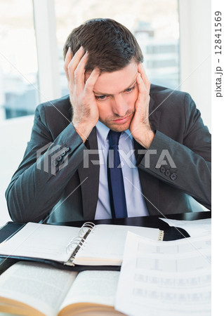 Stressed businessman with head in hands 12841569