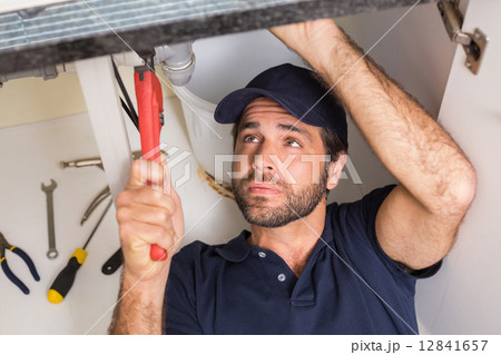 Plumber fixing under the sink Plumber fixing under the sink 12841657