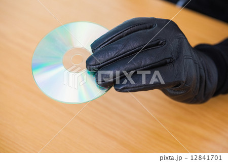 Hacker holding a cd rom 12841701