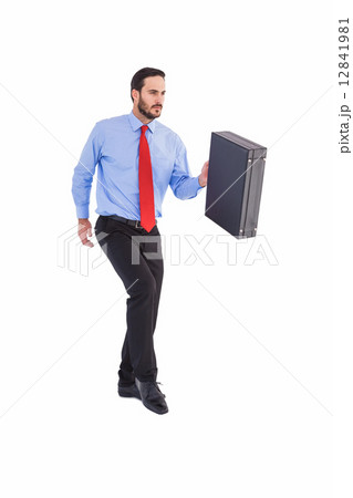 Businessman walking while holding briefcase Businessman walking while holding briefcase 12841981