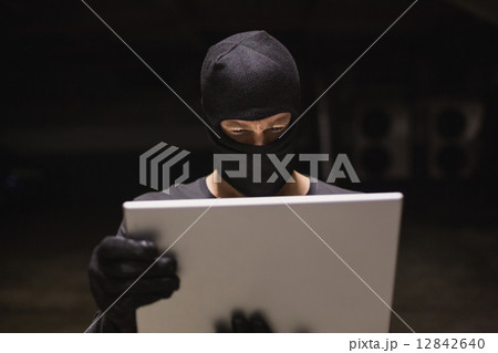 Hacker using laptop to steal identity 12842640