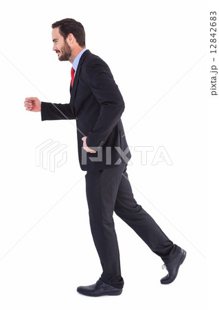 Smiling businessman stepping with hands raised 12842683