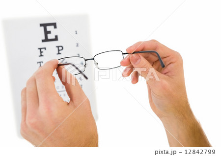 Glasses held up to read eye test Glasses held up to read eye test 12842799
