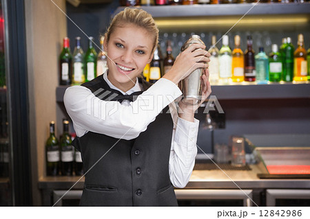 Pretty blonde waitress shaking cocktail 12842986