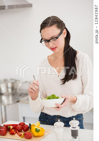 Pretty brunette preparing a healthy salad 12842987