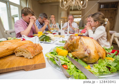 Family saying grace before christmas dinner together Family saying grace before christmas dinner together 12843041