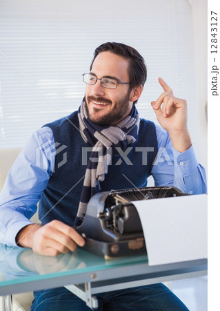 Smiling businessman working on typewriter 12843127