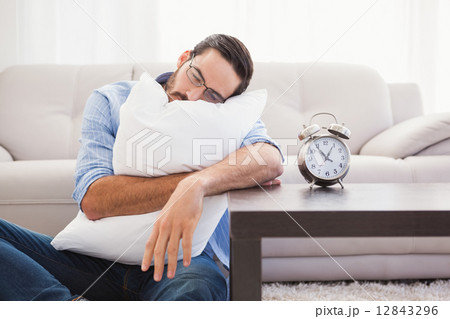 Exhausted man sleeping with head resting on pillow 12843296