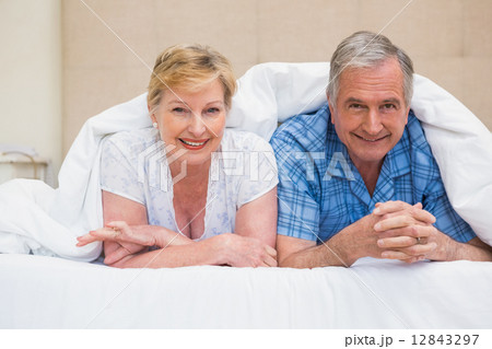Senior couple smiling under the duvet Senior couple smiling under the duvet 12843297