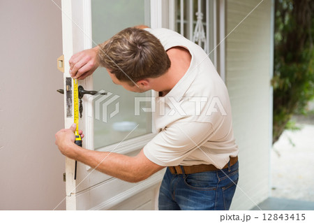Construction worker using measuring tape Construction worker using measuring tape 12843415