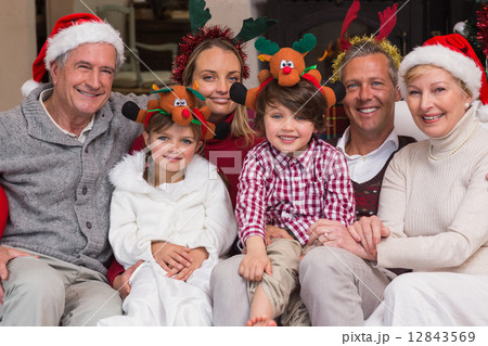 Multigeneration family wearing santa hats on the couch 12843569