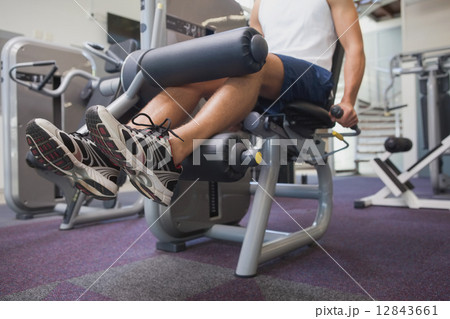 Fit man using weights machine for legs 12843661
