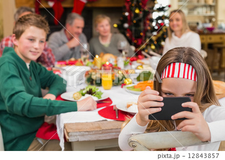 Little girl holding smartphone during christmas dinner 12843857