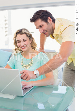Casual business team working together with laptop Casual business team working together with laptop 12843867