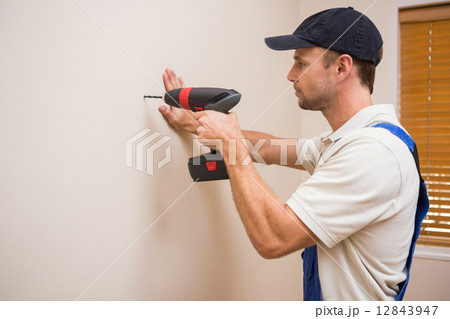Construction worker drilling hole in wall Construction worker drilling hole in wall 12843947