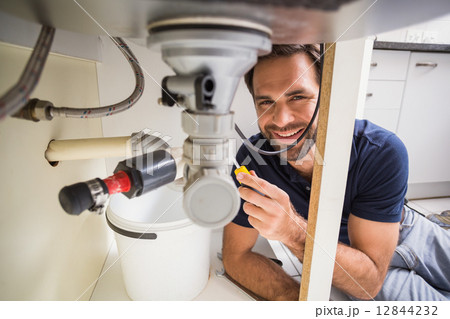 Plumber fixing under the sink 12844232