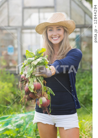 Happy blonde showing home grown vegetables Happy blonde showing home grown vegetables 12844294