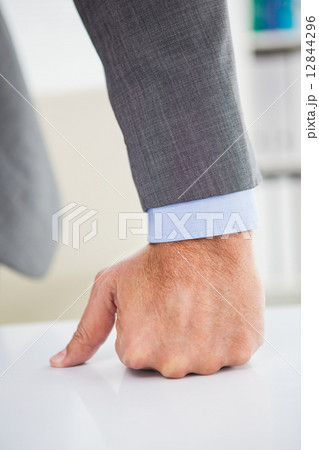 Businessmans fist clenched over desk Businessmans fist clenched over desk 12844296