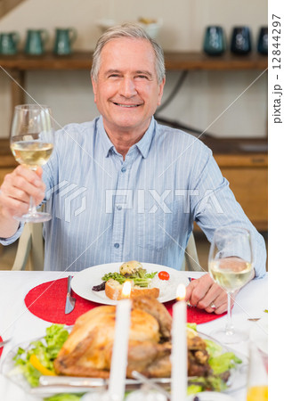 Smiling man toasting at christmas dinner 12844297