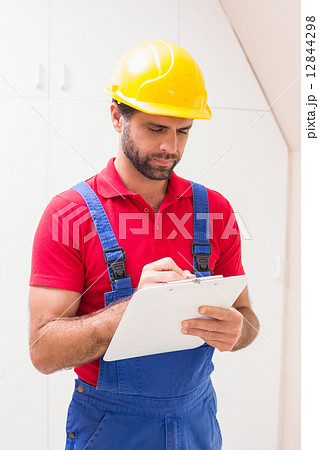 Construction worker taking notes on clipboard 12844298