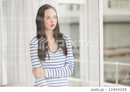 Pretty brunette looking out window Pretty brunette looking out window 12844299