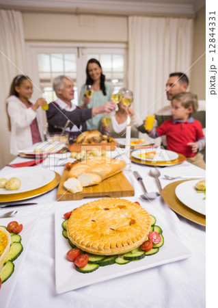 Smiling family toasting at christmas dinner Smiling family toasting at christmas dinner 12844331