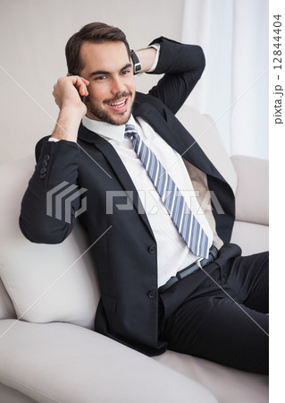 Businessman making a call on his couch 12844404