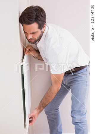 Handyman hanging up a radiator 12844439