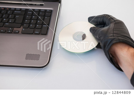 Burglar hacking and putting a cd-rom in laptop Burglar hacking and putting a cd-rom in laptop 12844809