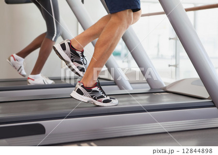 Fit people running on treadmills 12844898