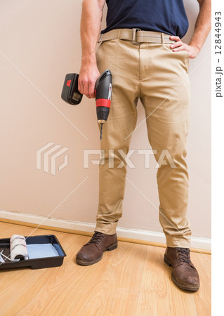 Construction worker holding power tool 12844943