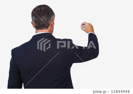 Rear view of a businessman writing with a chalk Rear view of a businessman writing with a chalk 12844948