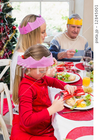 Little girl in party hat holding christmas crackers Little girl in party hat holding christmas crackers 12845001