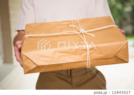 Close up of delivery man giving package 12845027
