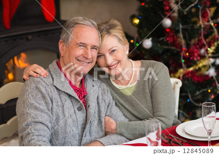 Portrait of smiling mature couple at table 12845089