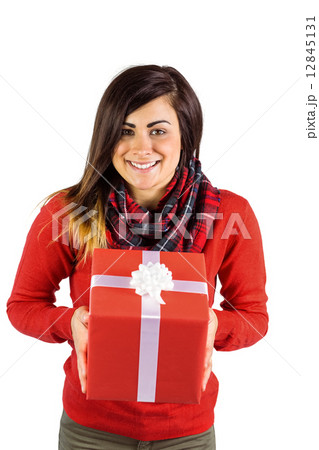 Smiling brunette showing a gift with white bow Smiling brunette showing a gift with white bow 12845131