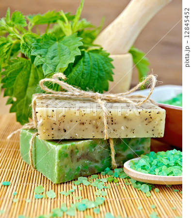 Soap homemade with nettles in mortar on board Soap homemade with nettles in mortar on board 12845452