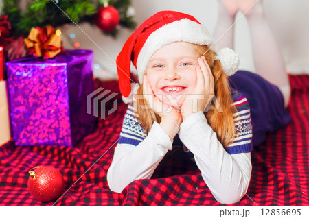 Little girl near the Christmas tree with gifts and toys 12856695